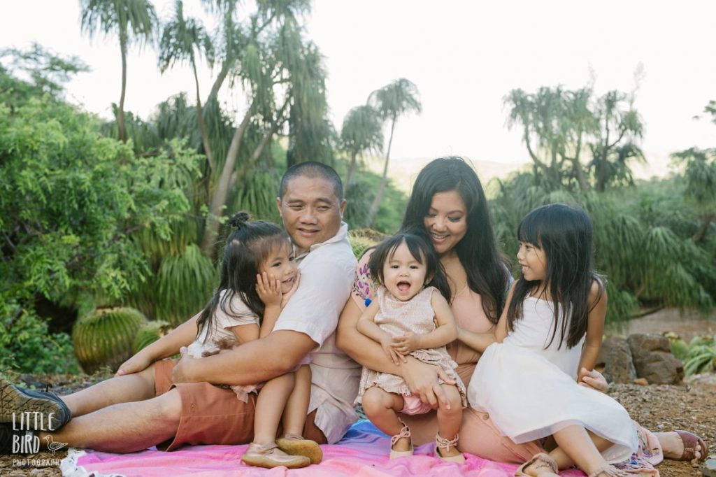 family sitting on a blanket in the botanical garden