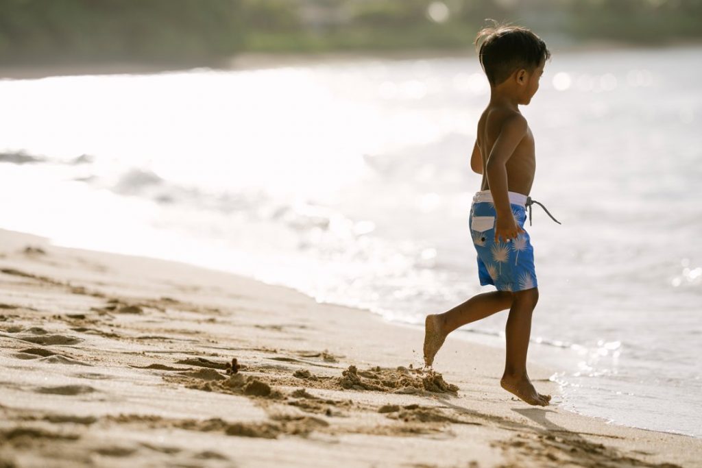 little boy playing in the water on the north shore of oahu