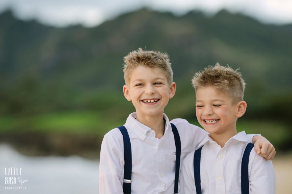 brothers in matching clothes sharing a laugh at a beach in hawaii