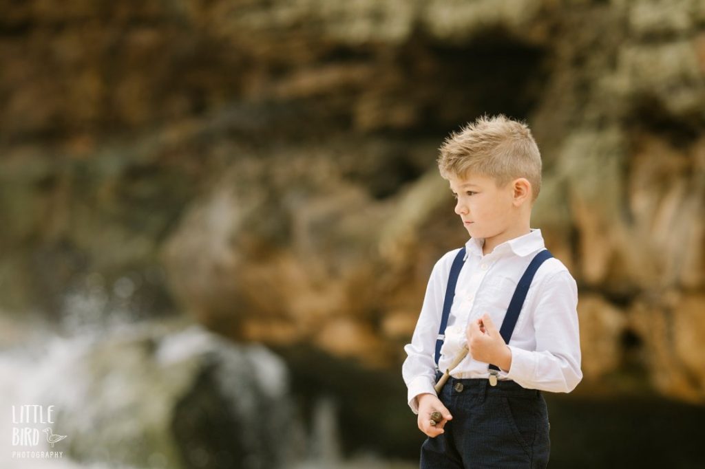 boy in suspenders at the beach in hawaii