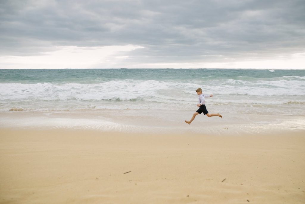 boy makes giant jump on the beach in hawaii